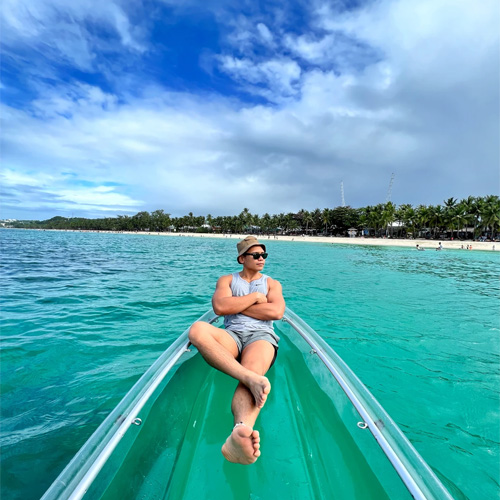 An image of Thom laying on a transparent boat while his arms are crossed